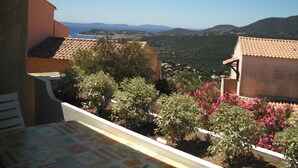 A terrace with a view of a coastal town and hills. - Stay on the peninsula of Saint Tropez at LA CROIX VALMER (La Croix-Valmer)