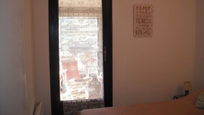 A room with a bed, a door with patterned curtains, and a motivational quote on the wall. - Stay on the peninsula of Saint Tropez at LA CROIX VALMER (La Croix-Valmer)