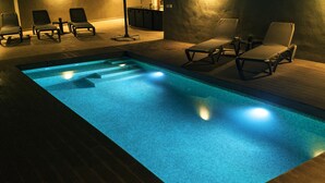 A swimming pool with a tiled edge, surrounded by lounge chairs and a wooden deck. - Ca na Patrona, viewpoint to Capdepera Castle. With pool and bbq (ETV / 8903) (Capdepera)