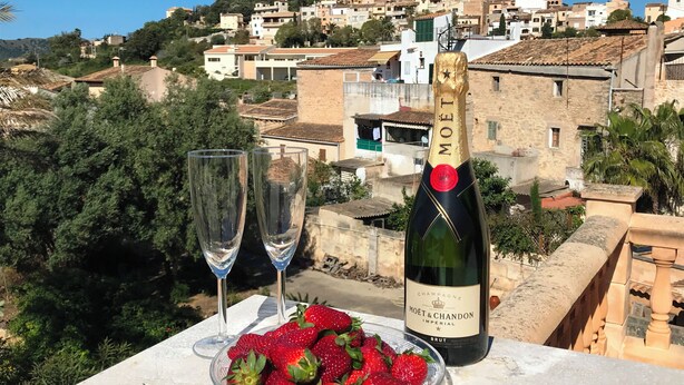 A table with a bottle of Moët & Chandon Imperial champagne, two glasses, and a bowl of strawberries.