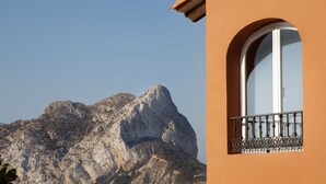 A building with a large arched window and a balcony with metal railings. - Villa with panoramic views of the sea and the Rock of Ifach, with private pool. (Calpe)