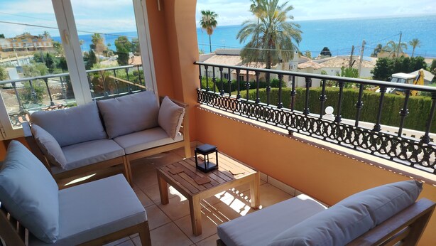 A balcony with a sofa, two armchairs, and a small table. - Villa with panoramic views of the sea and the Rock of Ifach, with private pool. (Calpe)