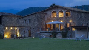 A stone building with a terrace and outdoor seating area.