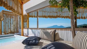 A poolside area with a sofa and cushions, a pergola with hanging ropes, and a view of the sea and mountains. - Casa Mariavittoria - My Rental Homes (Massalubrense)