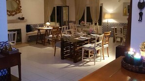 Un coin repas avec une table et des chaises en bois, une cheminée et un miroir au mur.