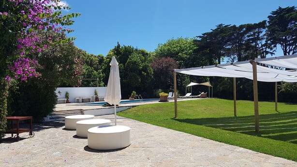 Un espace extérieur aménagé avec une piscine, des sièges et une pergola.