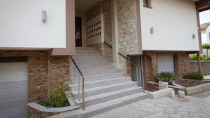 Un escalier menant à une porte dotée d’une façade en pierre et à une porte de garage.