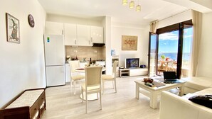 Un appartement moderne comprenant une cuisine, un coin repas, un salon et un balcon avec vue.