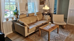 A cozy living room with a beige sofa, a wooden coffee table, and a patterned rug. - Idyllic vacation home right by the sea<br> (Docksta)