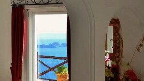 Ein Zimmer mit Meerblick, einem Balkon mit Geländer und einem Blumentopf.