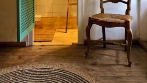 Une pièce avec une chaise en bois, une échelle en bois et une porte verte.