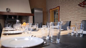 A dining table set with plates, cutlery, glasses, and a pitcher of water.