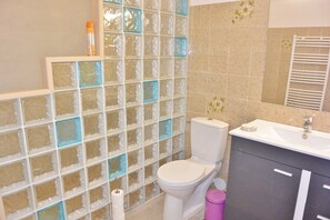 A bathroom with a toilet, a sink, and a glass block partition. - FIUMICELLI - 3* - SEA VIEW - WI-FI (SOLENZARA)