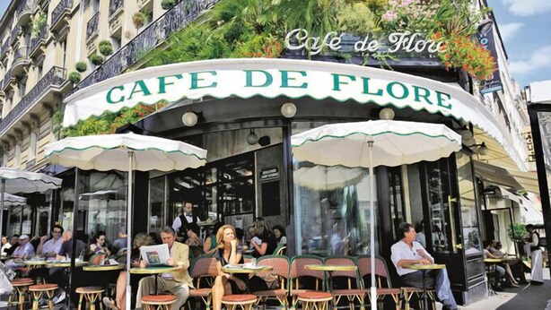 Un café appelé Café de Flore, doté d’une terrasse et d’un auvent incurvé.