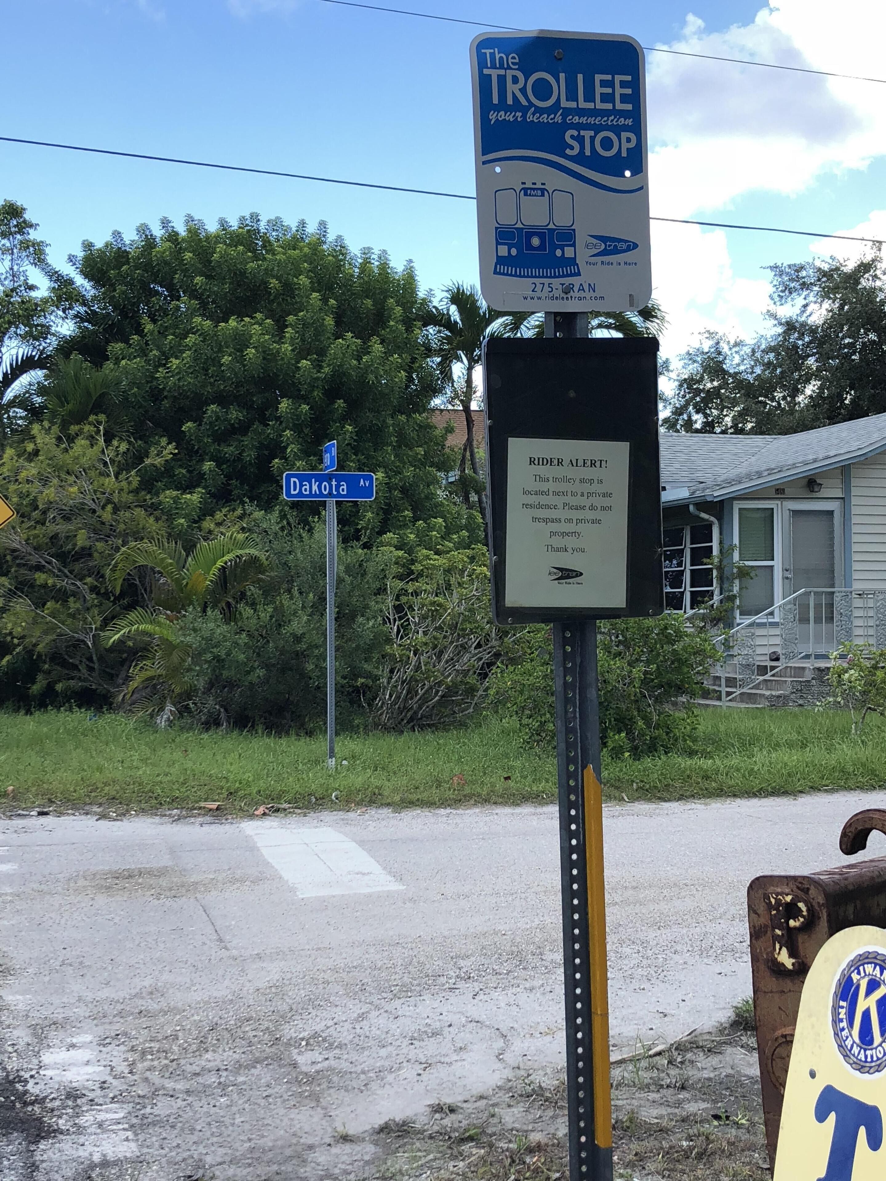 A trolley stop sign with a warning about trespassing on private property.