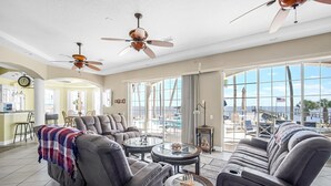 Ein geräumiges Wohnzimmer mit Ledersofas, einem Essbereich und Blick auf den Ozean.