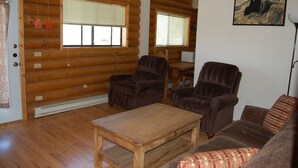 A log cabin interior with two armchairs, a sofa, and a wooden coffee table. - Cute 2/1 Cabin With Full Kitchen And Teton Views (Moran)