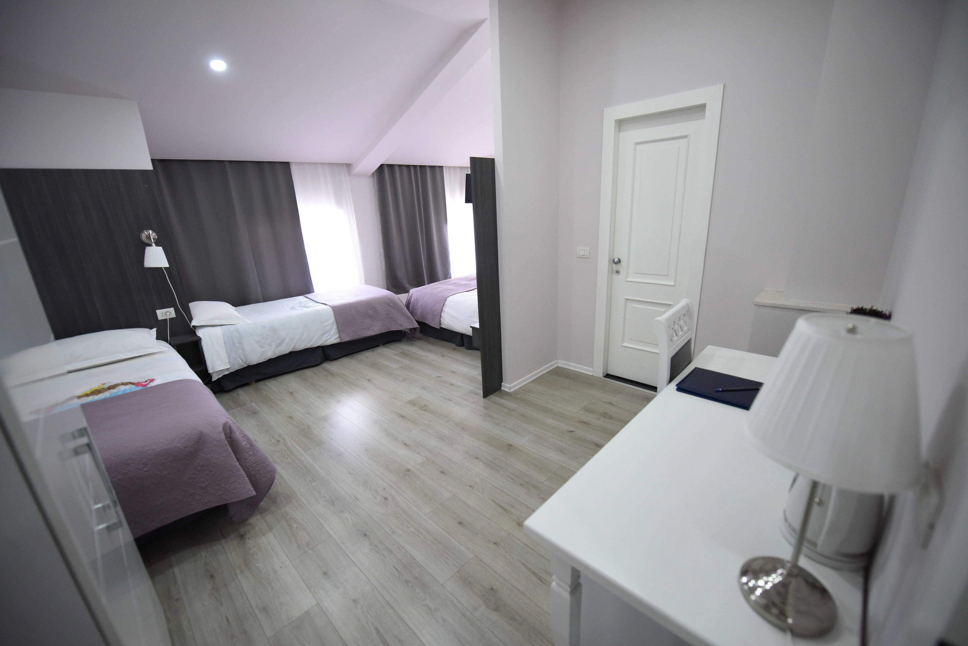 A modern hotel room with a bed, a desk, and a chair.