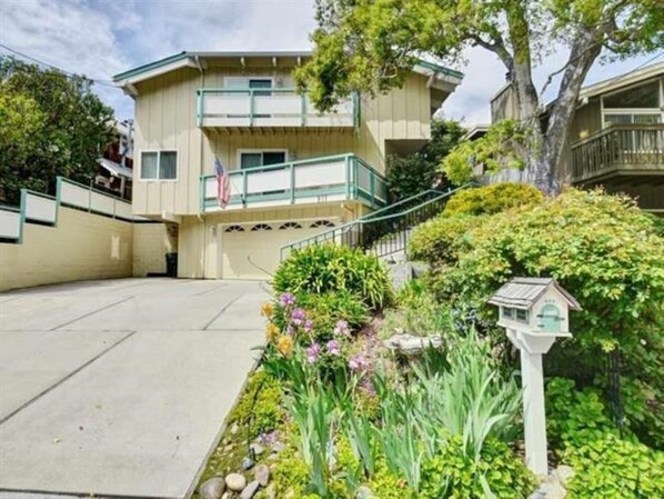 A two-story building with a balcony, a small garden with various plants, and a mailbox. - Rio Del Mar Aptos-two blocks to the Sand, Ocean, Store, Restaurant, Coffee shop (Aptos)