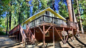 Eine Holzhütte mit einer Holzterrasse und einer Treppe, die zu einer zweiten Ebene führt.