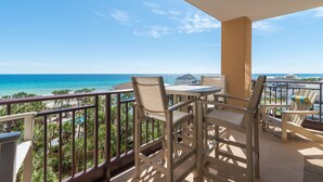 Un balcon avec vue sur l’océan, équipé d’une table et de chaises.