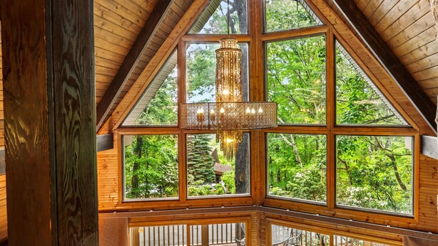 A room with a large window, wooden ceiling, and a hanging light fixture. - Honey Bear– Unique A-Frame Chalet w/ Mt LeConte View & Hot Tub in Gatlinburg (Gatlinburg)