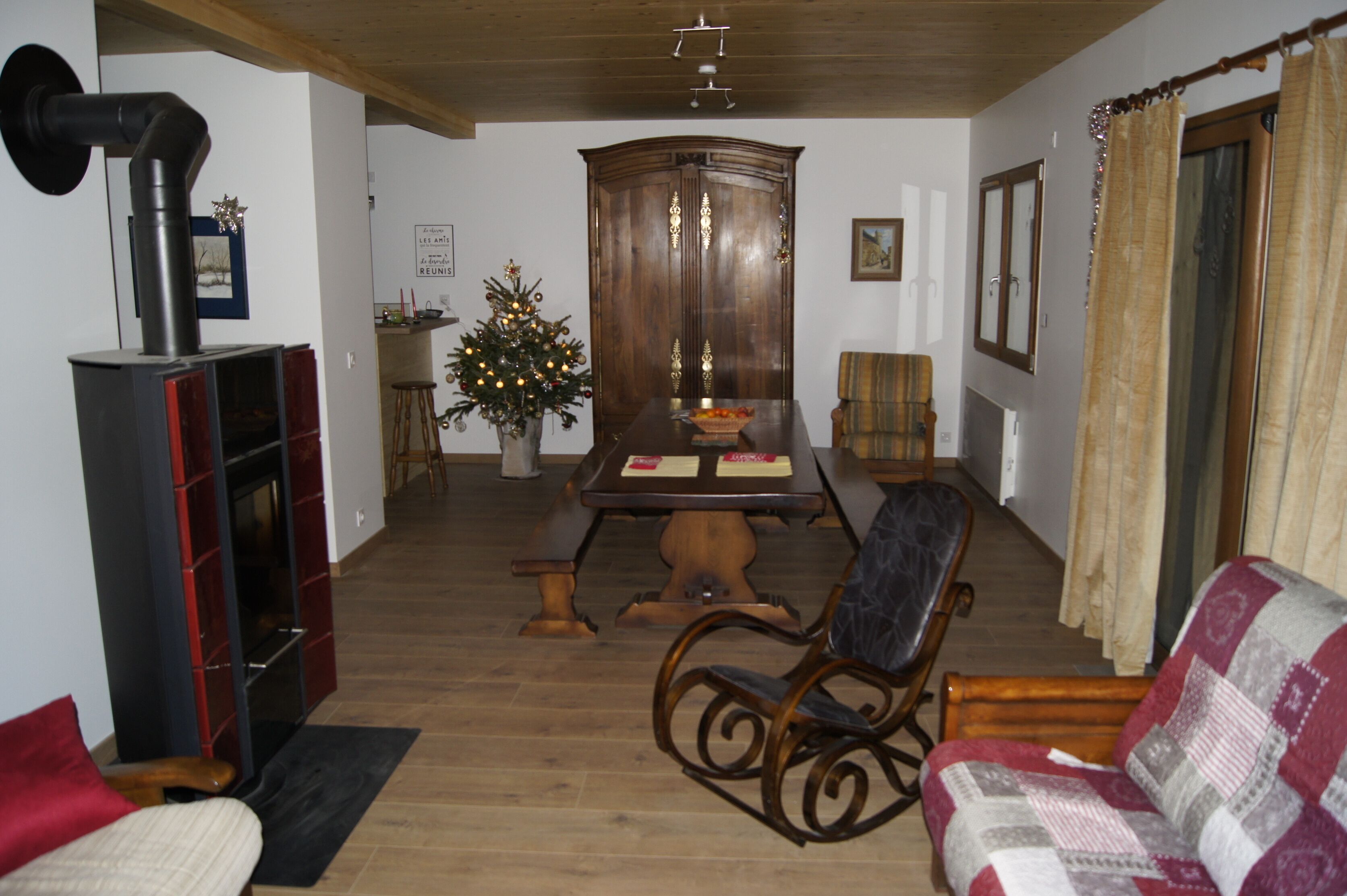 Ein Essbereich mit einem Holztisch, Stühlen und einem Weihnachtsbaum.