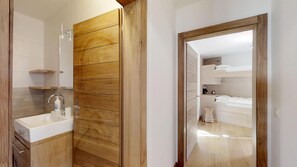 Ein modernes Badezimmer mit einem Holzkosmetikschrank, einem Waschbecken und einem Spiegel.