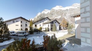 Ein Hotel mit mehreren Gebäuden, einem Parkplatz und verschneitem Gelände, im Hintergrund Berge.