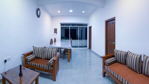 A modern living room with a sofa set, a dining table, and a coffee table. - Heaven Hills Guest House (Maskeliya)