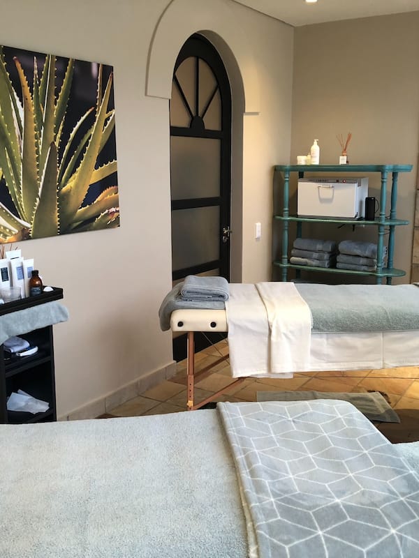 Relax in a serene spa room with two treatment beds and a selection of toiletries.