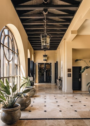 A spacious hallway with a high ceiling, large windows, and potted plants. - Sante Wellness Retreat & Spa (Paarl)