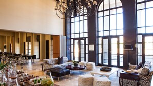 A spacious lobby with high ceilings, large windows, and a chandelier. There are seating areas with patterned sofas and ottomans. - Sante Wellness Retreat & Spa (Paarl)