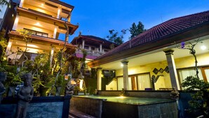 A traditional building with multiple floors, a courtyard with a fountain, and a well-lit entrance. - Ubud Wins Bungalow (Ubud)