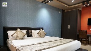 A neatly made bed with a dark headboard, a wooden nightstand, and a chair to the right.