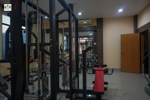 Un gimnasio con diversos equipos de ejercicio, incluyendo máquinas de pesas y mancuernas.