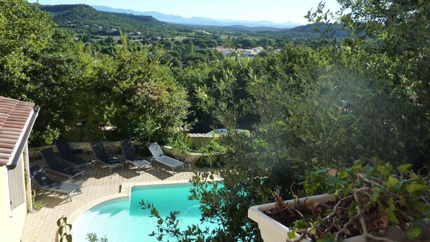 A pool surrounded by lounge chairs and greenery, with a view of a hilly landscape in the background. - Villa with private pool, views of the Ventoux (Saint Paul trois Chateaux)