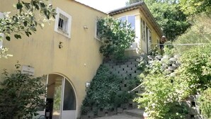 A yellow building with a stone staircase and a door leading to a covered entrance. - Villa with private pool, views of the Ventoux (Saint Paul trois Chateaux)
