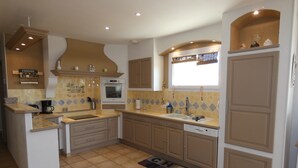 A kitchen with a central island, built-in oven, and a window above the sink. - Villa with private pool, views of the Ventoux (Saint Paul trois Chateaux)
