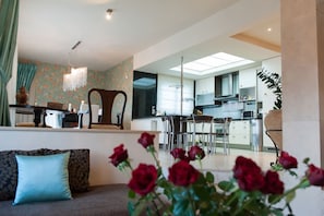 Una sala moderna con un sofá, un comedor y una cocina.