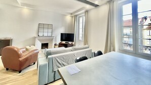 Un salon moderne avec une cheminée, un téléviseur, un canapé et une table à manger.