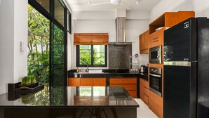 A modern kitchen with a large island, built-in oven, microwave, and refrigerator. - Emotion 1 - 3 Bedrooms, Rawai - Phuket (Rawai)