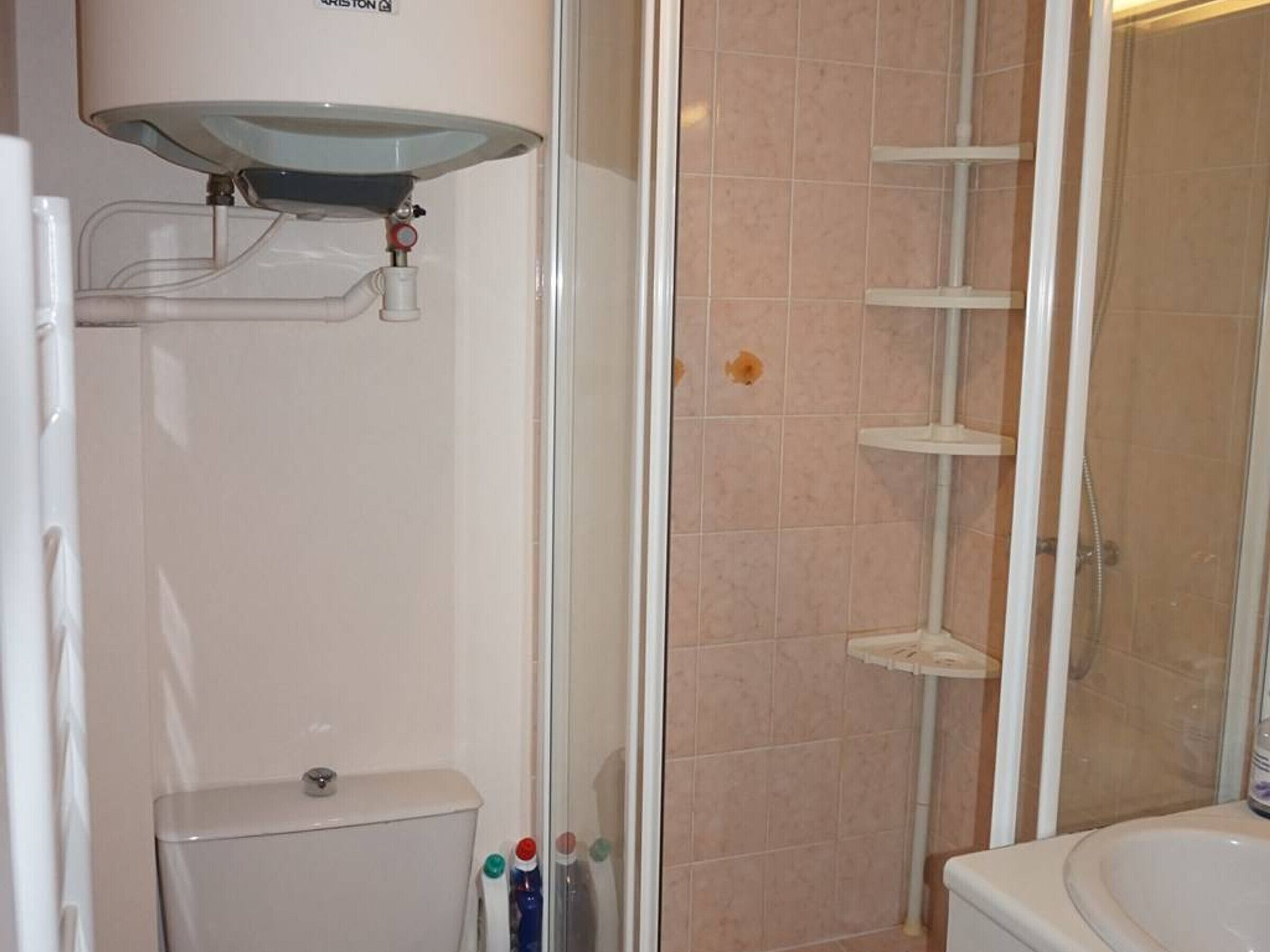 Un baño con inodoro, cabina de ducha y lavabo.
