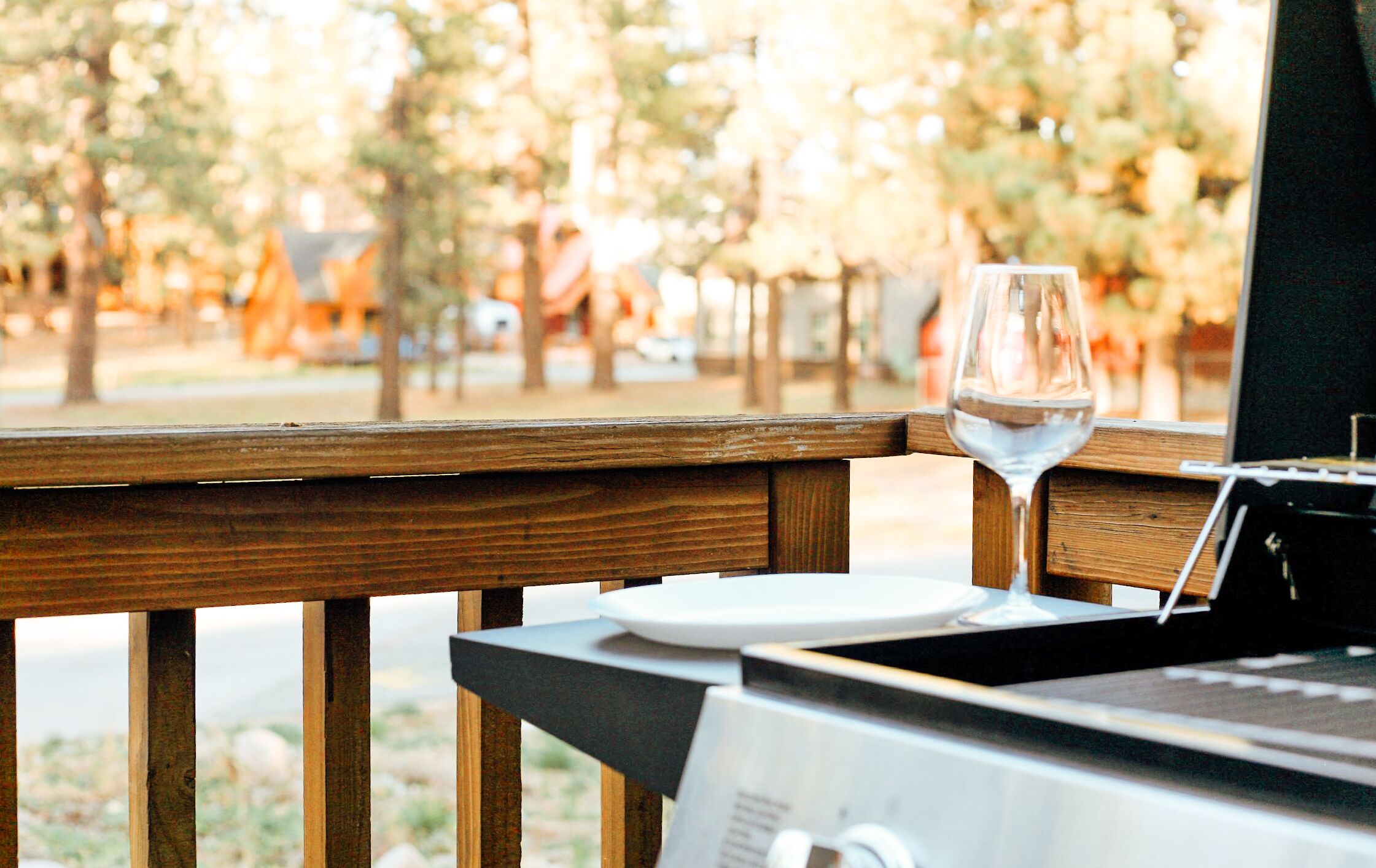 A wooden deck with a table, a wine glass, and a menu.