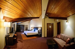 Een hotelkamer met een groot bed, een sofa, een bureau en een kledingkast.