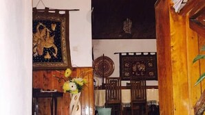 A staircase leading to a room with a wooden floor, a painting on the wall, and a table with a vase of flowers. - grymsby holiday bungalow (Nuwara Eliya)