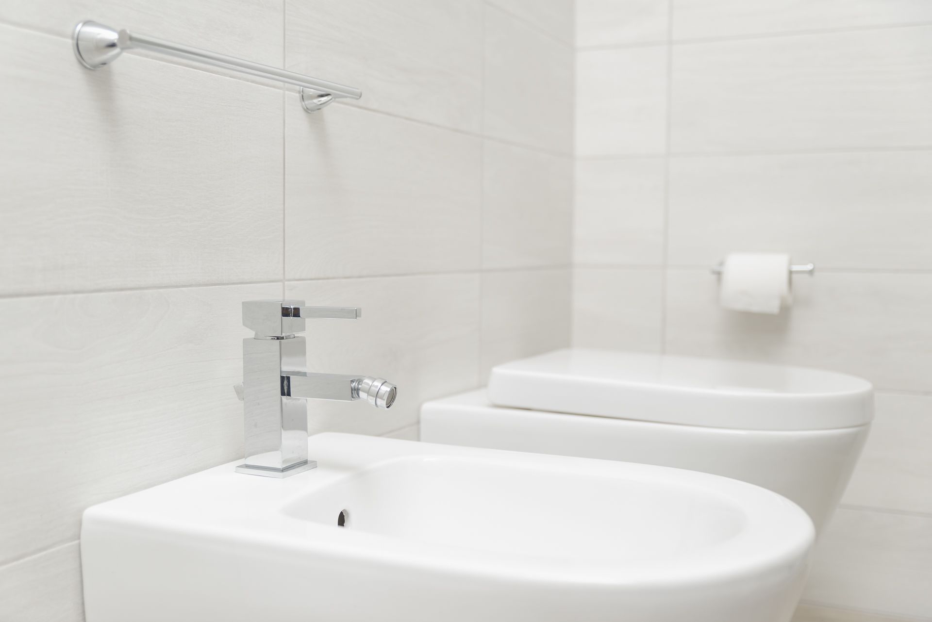Une salle de bain avec un lavabo blanc, des toilettes et un porte-serviettes.