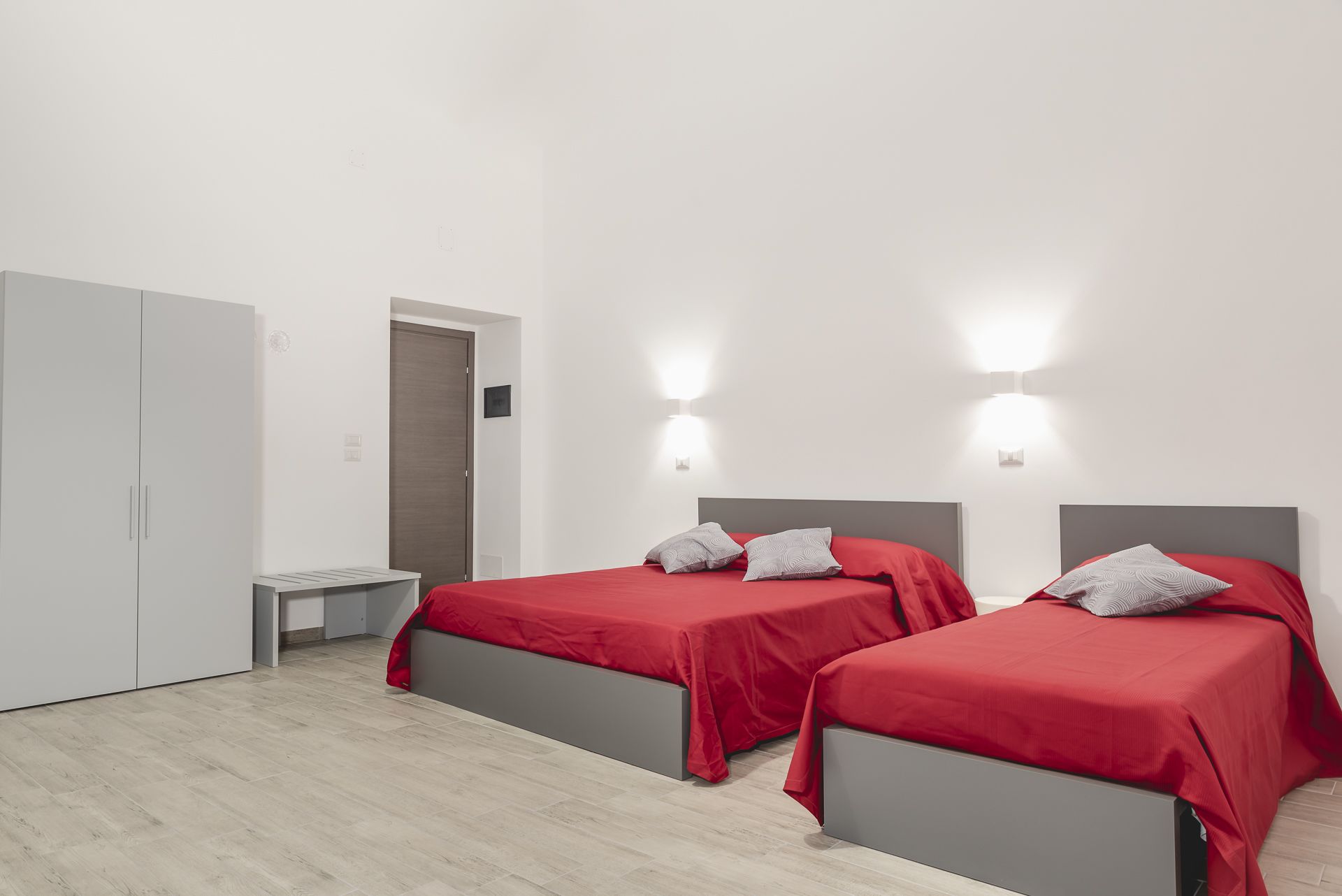 Ein Hotelzimmer mit zwei Betten, einem Schreibtisch und einem Kleiderschrank.