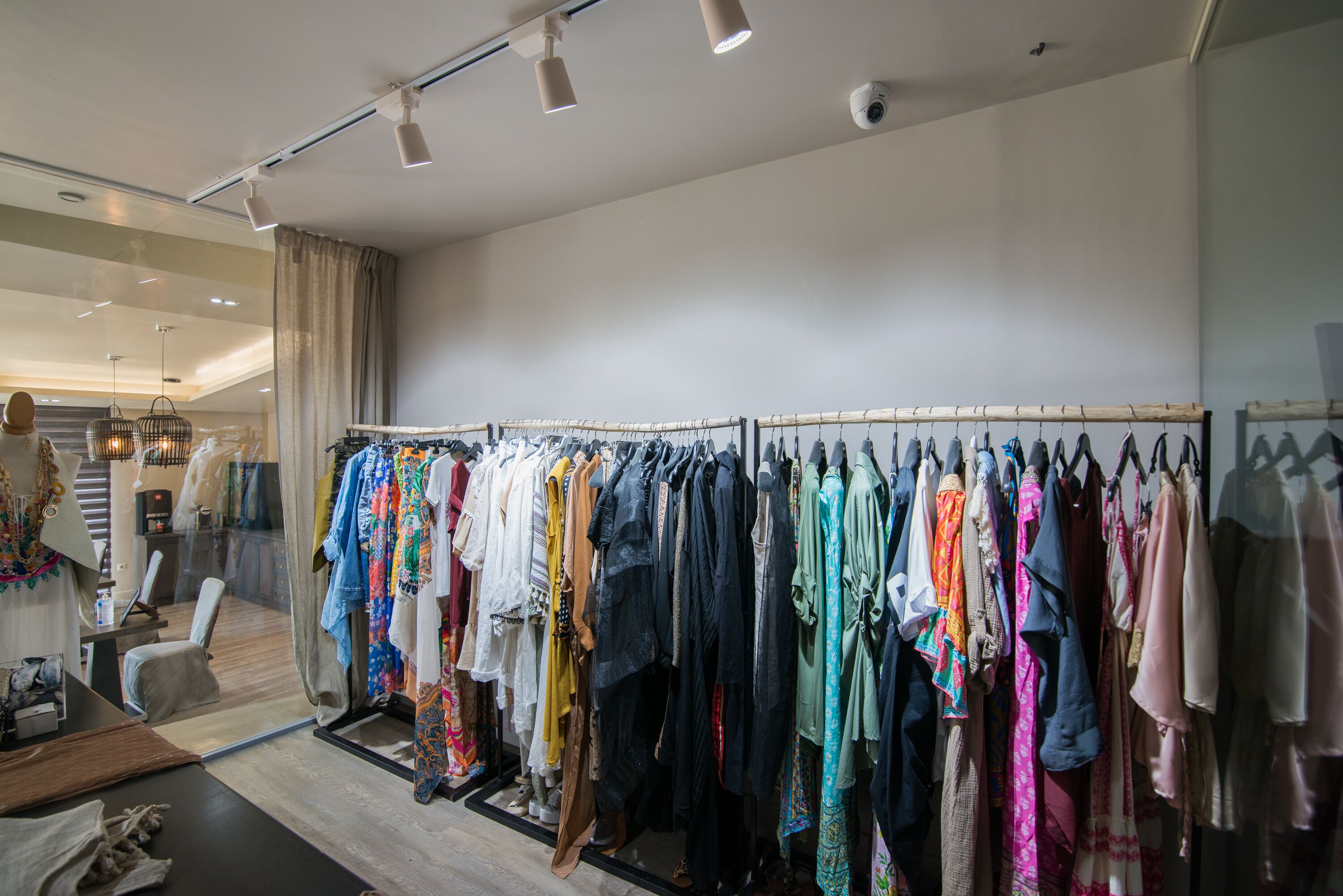 Un magasin de vêtements où l’on trouve une grande variété de vêtements présentés sur des portants.