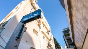 A building with a 'WELCOME' sign, a visible window, and a balcony. - Double O apartment - Near the bech (Tel Aviv)